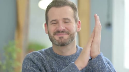 Man Smiling and Clapping Hands in Appreciation