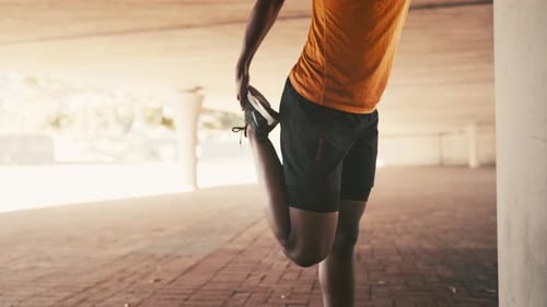 Athlete Stretches Leg in Urban Setting