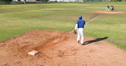 Playing baseball, pitcher throwing ball while batter running to first base