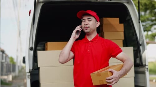 Delivery man, driver calling to customerr for sending parcel box package in the cargo truck at home