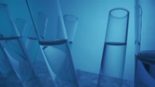Close Up Video Neon Blue Light Test Tubes Filled with Fluid in a Laboratory Scientific Experiment