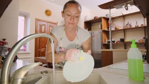 Woman Washing Dishes at Kitchen Sink
