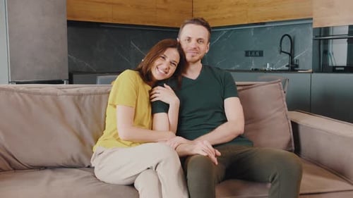 Loving Couple Smiling Together on Couch