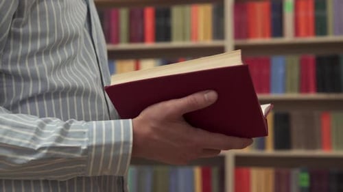 Un étudiant se promène entre des rangées d'étagères à la recherche d'un livre approprié pour se préparer à un examen.