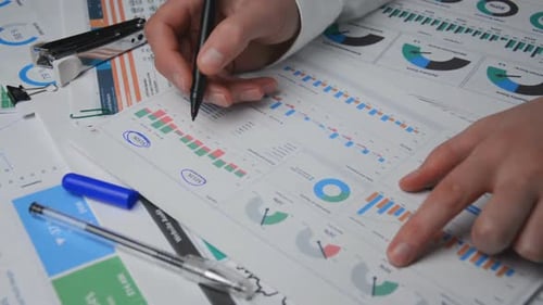Man Analyzing Charts at a Desk