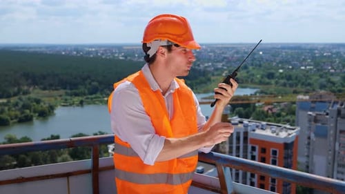 Man with Walkie-Talkie on City Rooftop