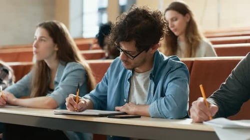 Students Attending Lecture and Taking Notes in Classroom