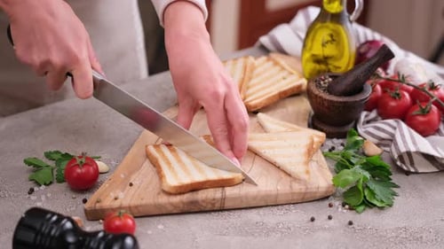 Cutting Grilled Bread on Cutting Board for Bruschetta