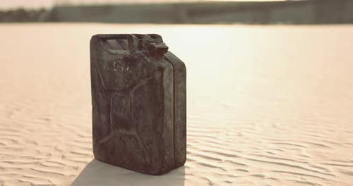 Rusty Canister Rests on Sandy Ground Under Bright Sunlight in Open Area