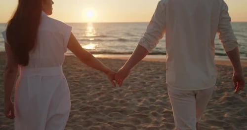 Young Loving Couple Enjoying Relaxing Sunset Walk on the Beach