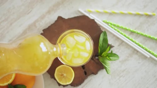Fresh Citrus Beverage Poured into Glass with Ice