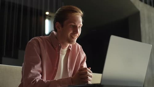 Lowangle View of Happy Smiling Man Sitting on Couch Looking at Laptop Camera Making Video Webcam