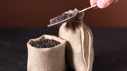 Loose Leaf Tea Scooped from Sack in Studio Setting