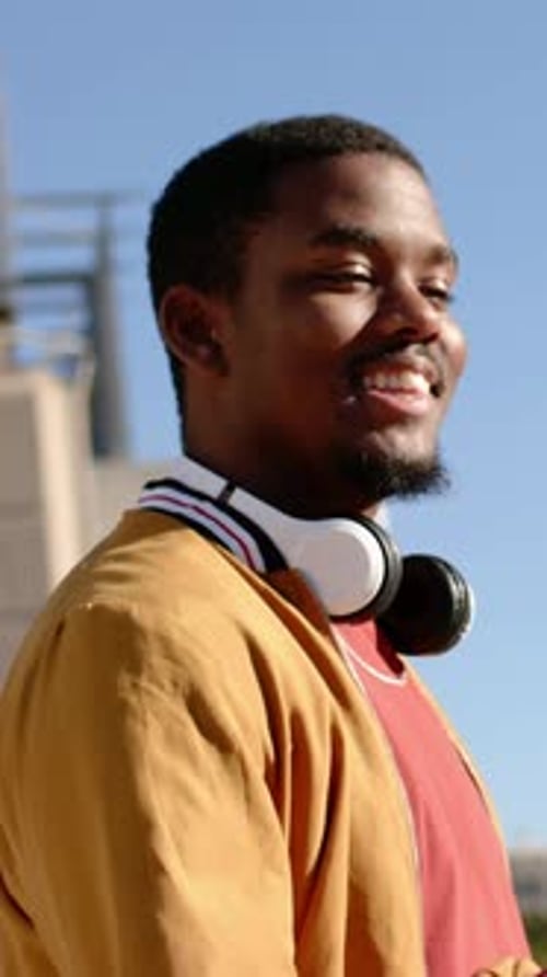 Vertical video: Pulling camera back man looking, bouncing ball at plaza with jacket, copy space