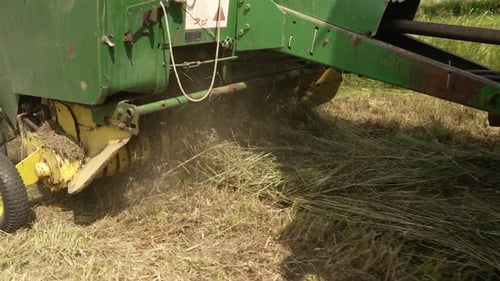 Traktor sammelt trockenes Heu auf dem Feld