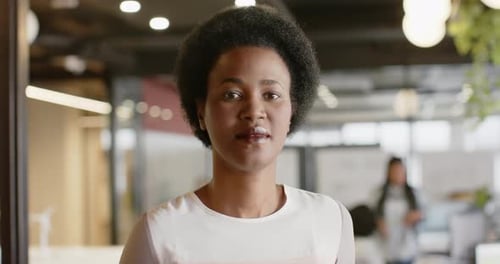 Portrait of happy african american casual businesswoman smiling at office, slow motion