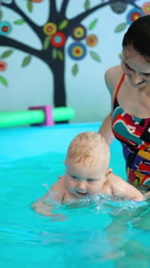 Happy Infant Swimming with Adult in Bright Pool