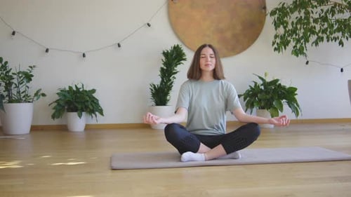 Woman Meditating in a Peaceful, Plant-Filled Home