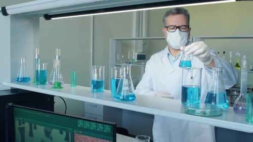 Man Examines Blue Liquid in Laboratory Setting