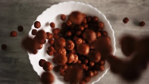 Chocolate Cereal Balls Being Poured Into a Bowl