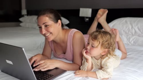 Face of Mother Lights Up with Smile Looking at Laptop Screen