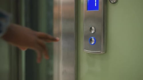 Per Hand drückender Aufzugsknopf mit beleuchtetem blauem Pfeil, der die Aufwärtsrichtung anzeigt