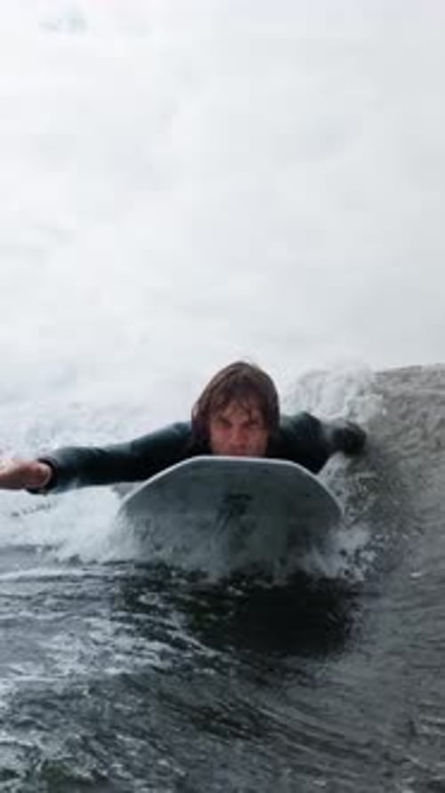 A Dynamic Surfing Experience A Surfer Riding the Waves with Determination and Skill in a Thrilling