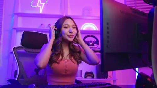 Smiling Woman Sitting at Computer Gaming Station