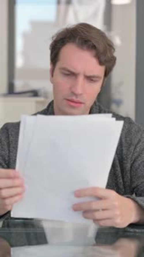Man Examines Documents in Brightly Lit Room