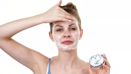 Woman Applying Cosmetic Cream to Her Face