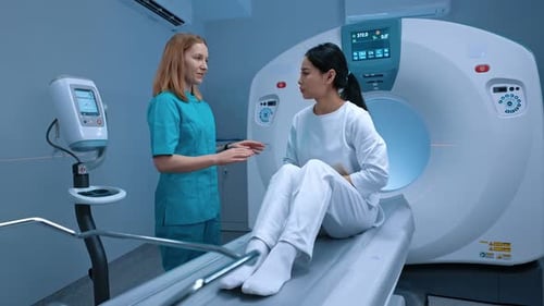 Woman on CT Scanner Bed Talking to Staff
