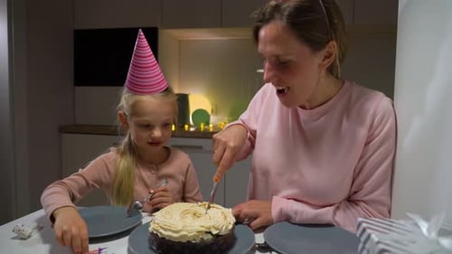 Mother and Child Cutting Birthday Cake at Home