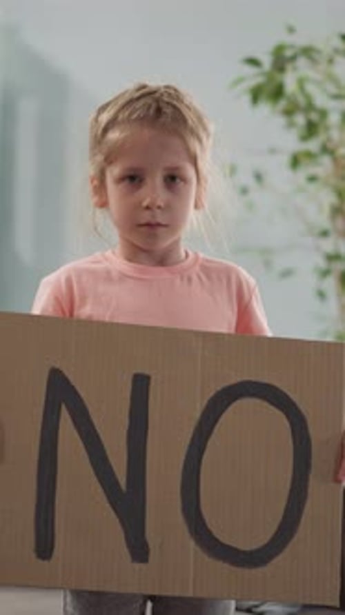 Young Girl Holding Sign That Says No Indoors