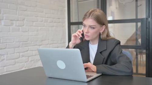 Businesswoman Talking on Phone in Office
