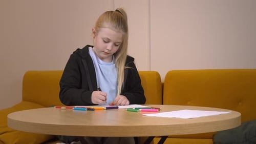 Girl Drawing with Markers at Table Indoors