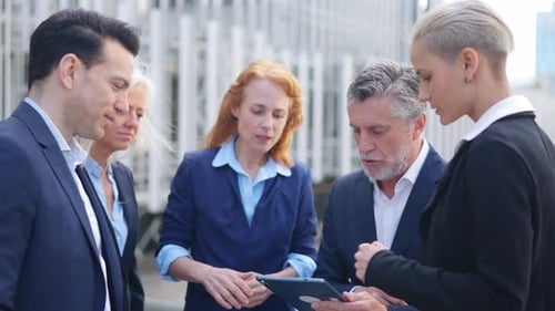 Homme d'affaires répartissant les tâches entre ses employés à l'aide d'une tablette