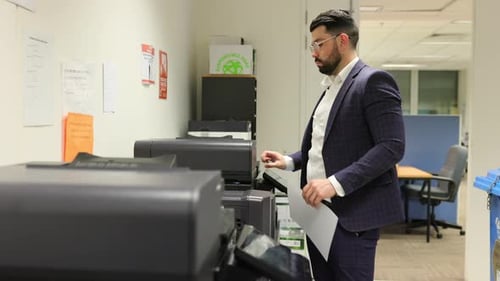 Business Man In Office At Photo Copier Room Station Printing Copying Files Documents