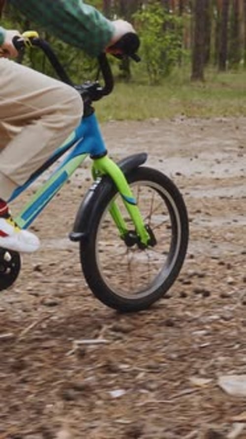 Side View of Boy Cycling Through Forest