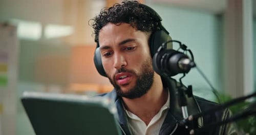 Tablet, talking and man with mic in studio for podcast, broadcast or interview with online