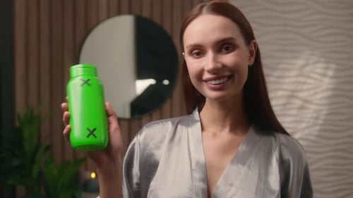 Woman in Robe Holding Green Screen Bottle