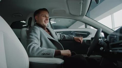 Happy Man Expresses Satisfaction of Car Ownership in Dealership