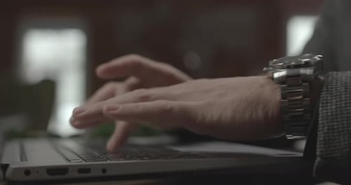 Businessman with Wristwatch Writes Email on Laptop in Office