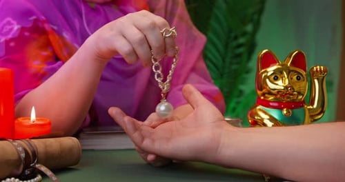 Fortune Teller Holding Pearl Necklace Over Open Hand