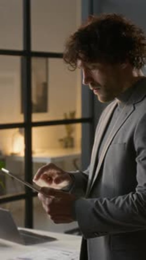 Adult Using Tablet in Modern Office at Night