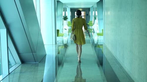 Elegant young woman enjoying a casual stroll through a modern city hallway