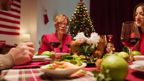 Family Gathered Around Christmas Table in Home