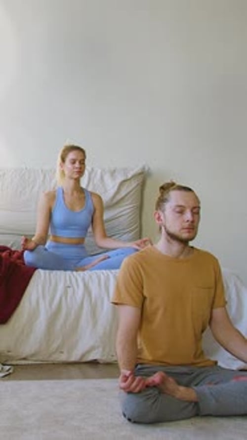 Couple Meditating Peacefully in Bright Bedroom