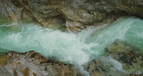 Rapid clear fresh water of mountain river flows among the rocks in rocky gorge. Fast flowing stream