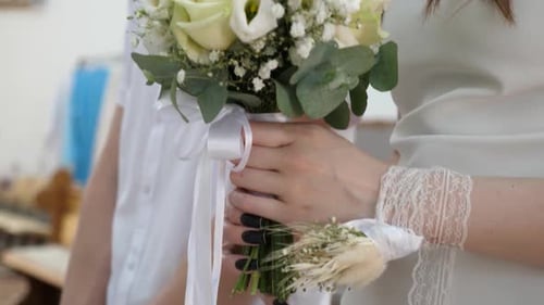 36. The girl in the church holds a bouquet of flowers in her hands.