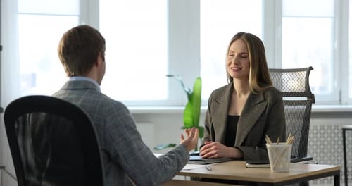 Lächelnder Personalvermittler und Kandidat beim Vorstellungsgespräch am Tisch im Büro